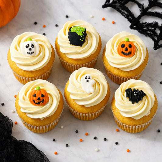 Halloween cupcake toppers on frosted cupcakes - pumpkin, cauldron, ghost and bat